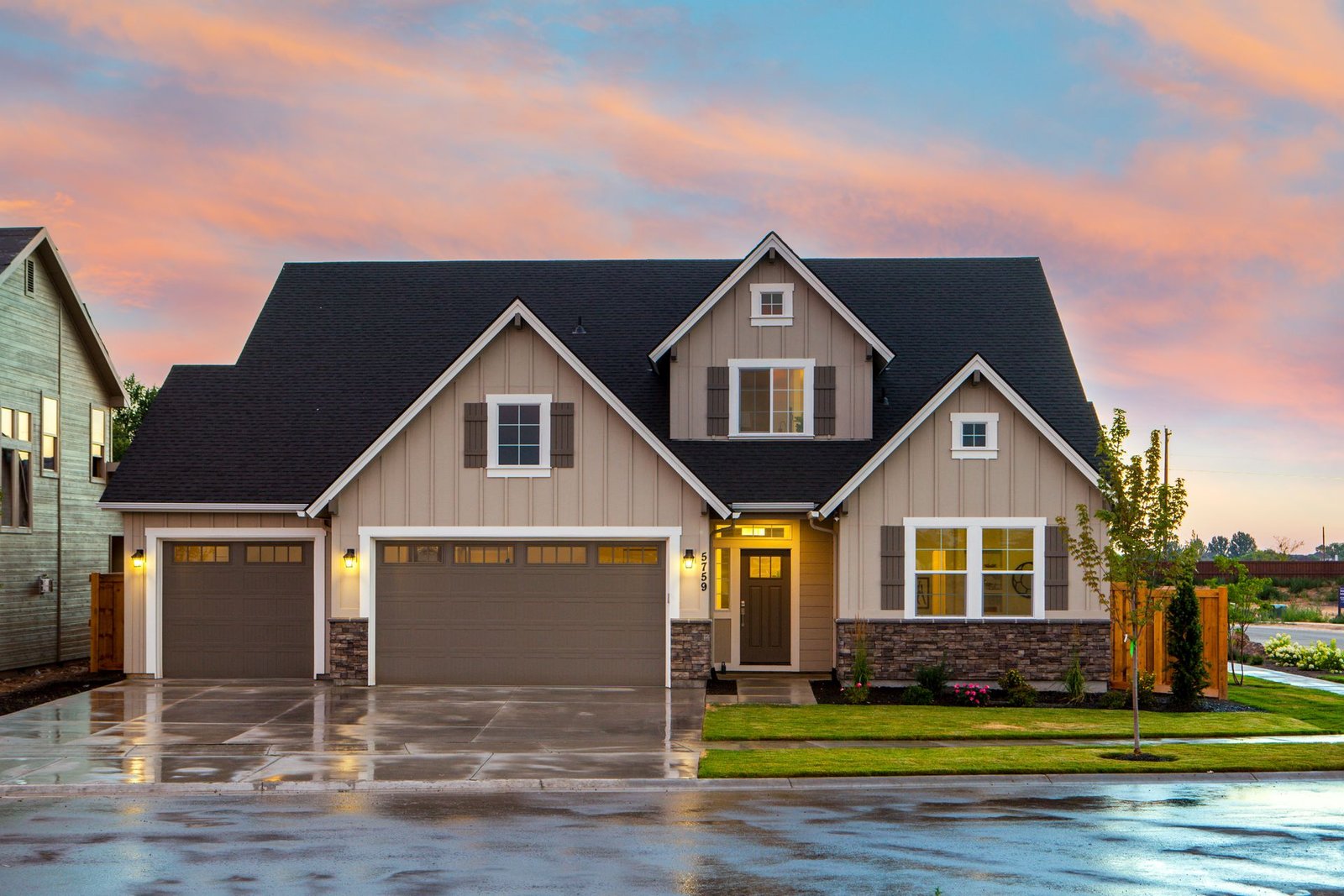A neighborhood home with warm lights at sunset